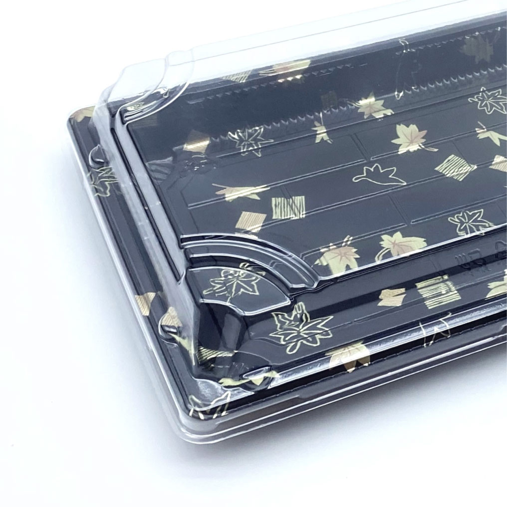 Close-up of a black sushi tray with a decorative pattern, featuring a clear, fitted lid.