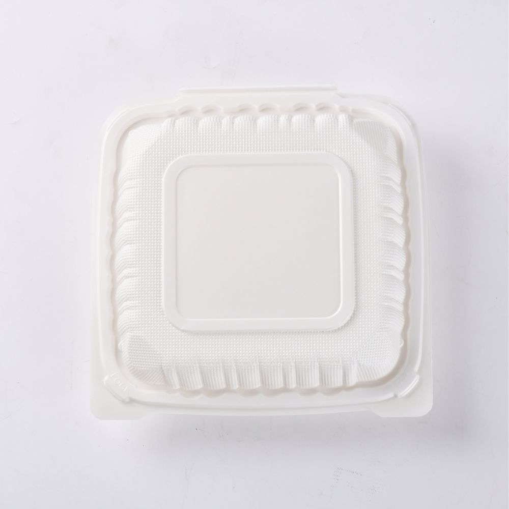 An overhead shot of a white clamshell bento box placed on a white background