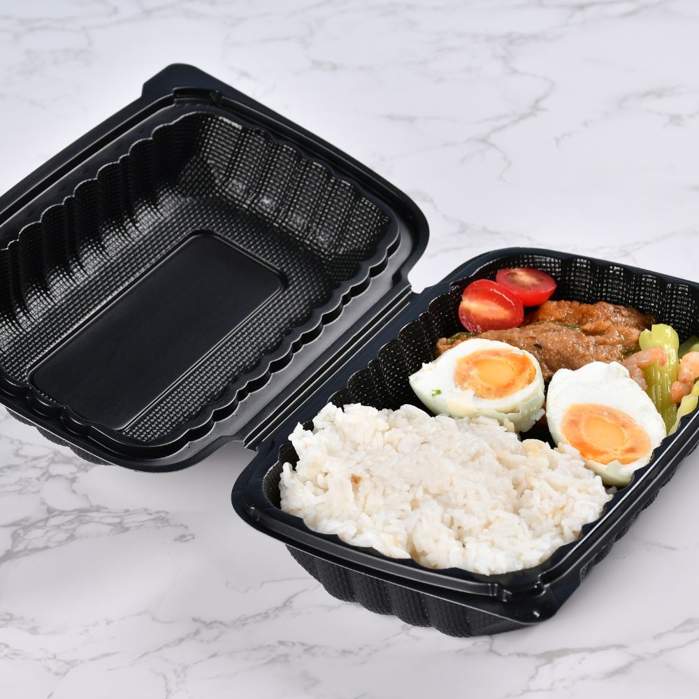 A black rectangular clamshell container with an open lid holds rice, eggs, meat and vegetables