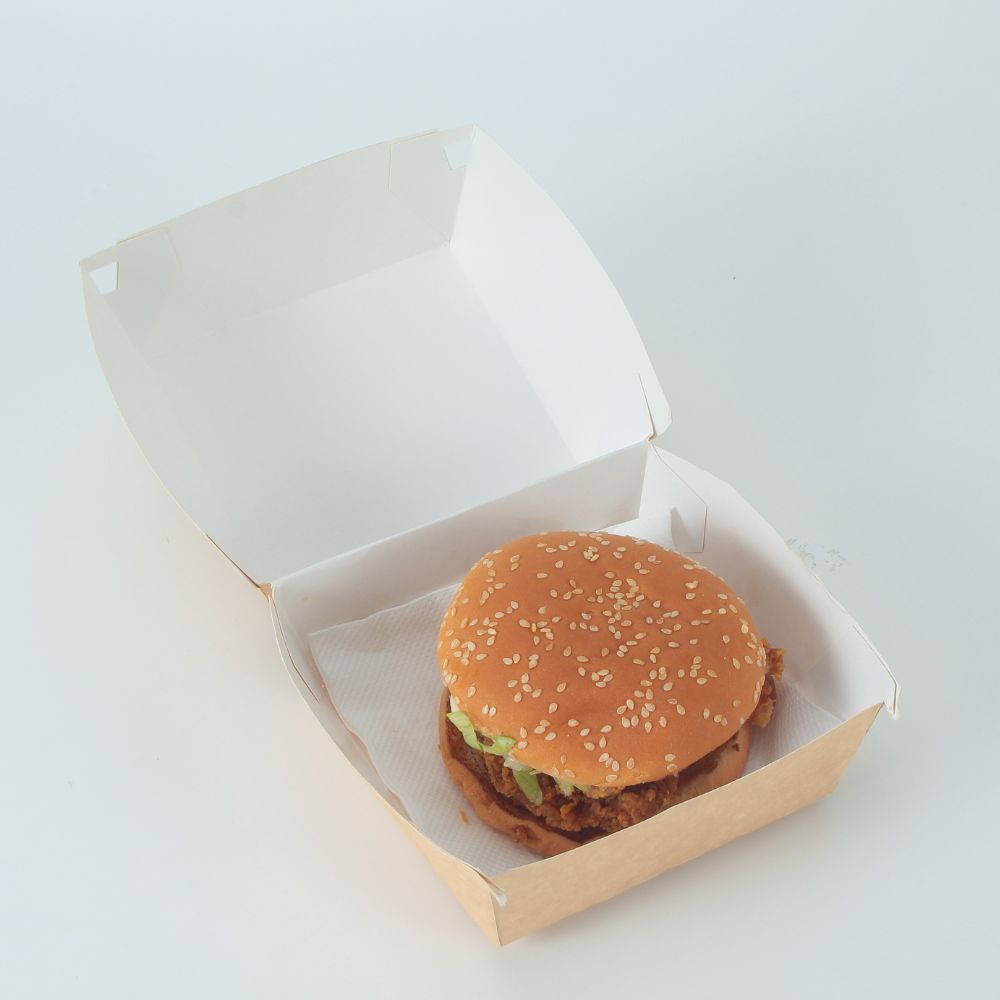A kraft paper clamshell storage container containing a burger placed on a light gray background