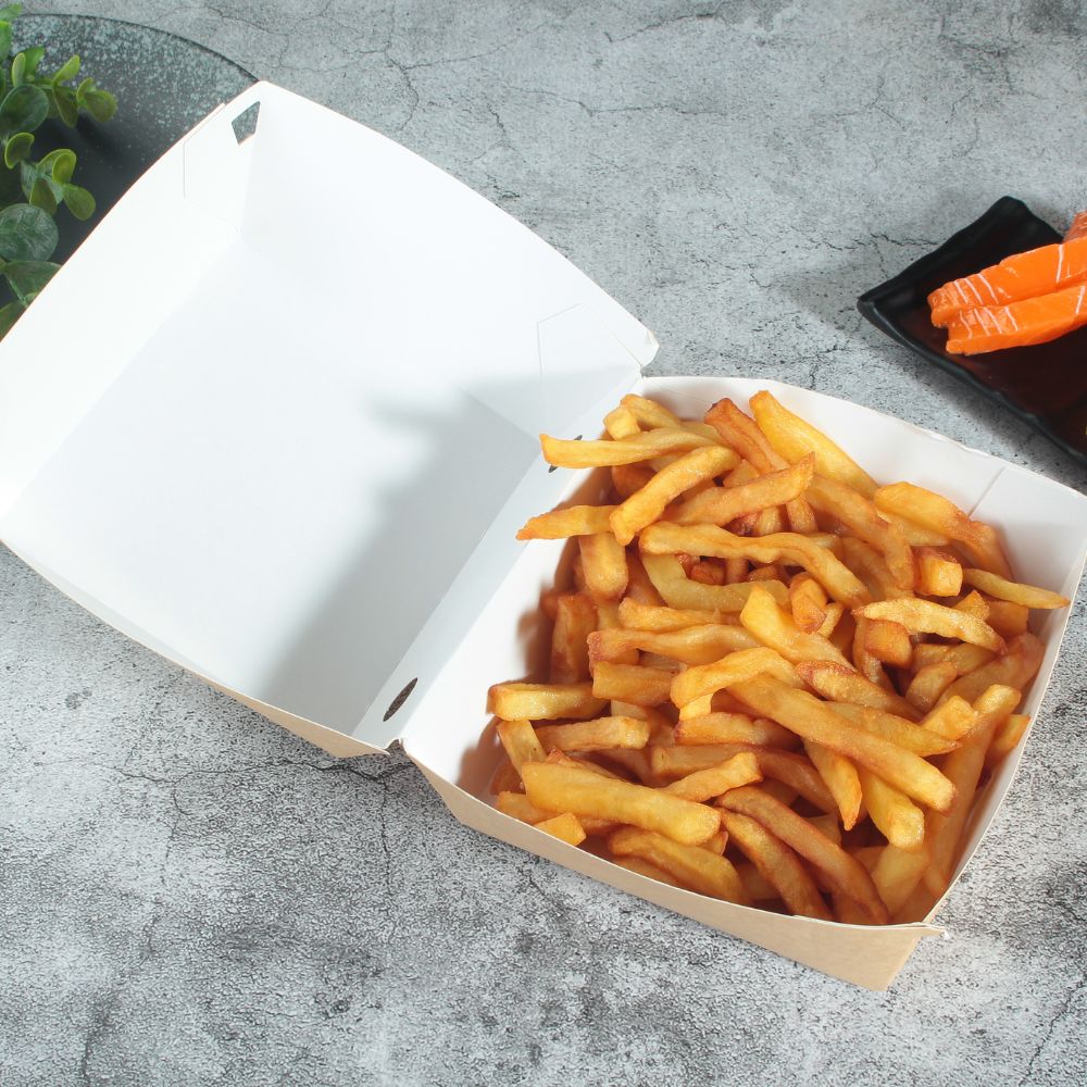 A kraft paper clamshell storage container filled with French fries lies on a gray tabletop