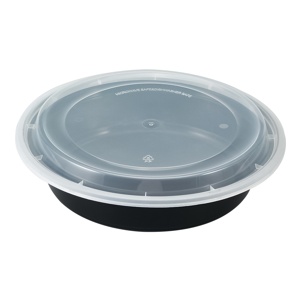 A black round plastic bento box with a closed lid placed on a white background