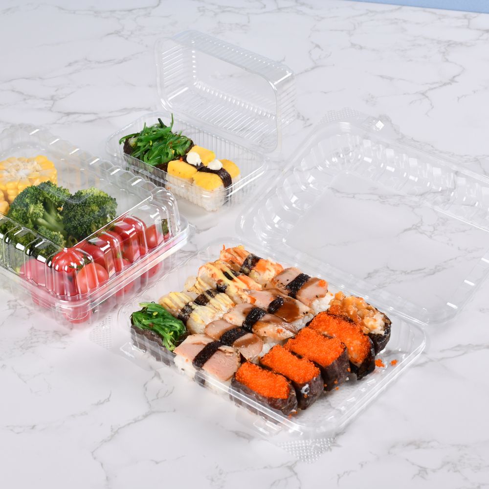 3 clear clamshell containers of different sizes containing corn, broccoli, cherry tomatoes and sushi on a light gray table