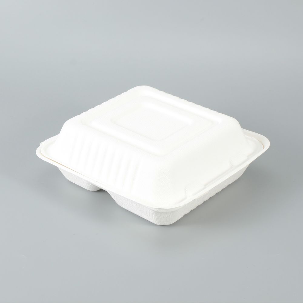 A white 3-compartment biodegradable bagasse clamshell box on a grey background