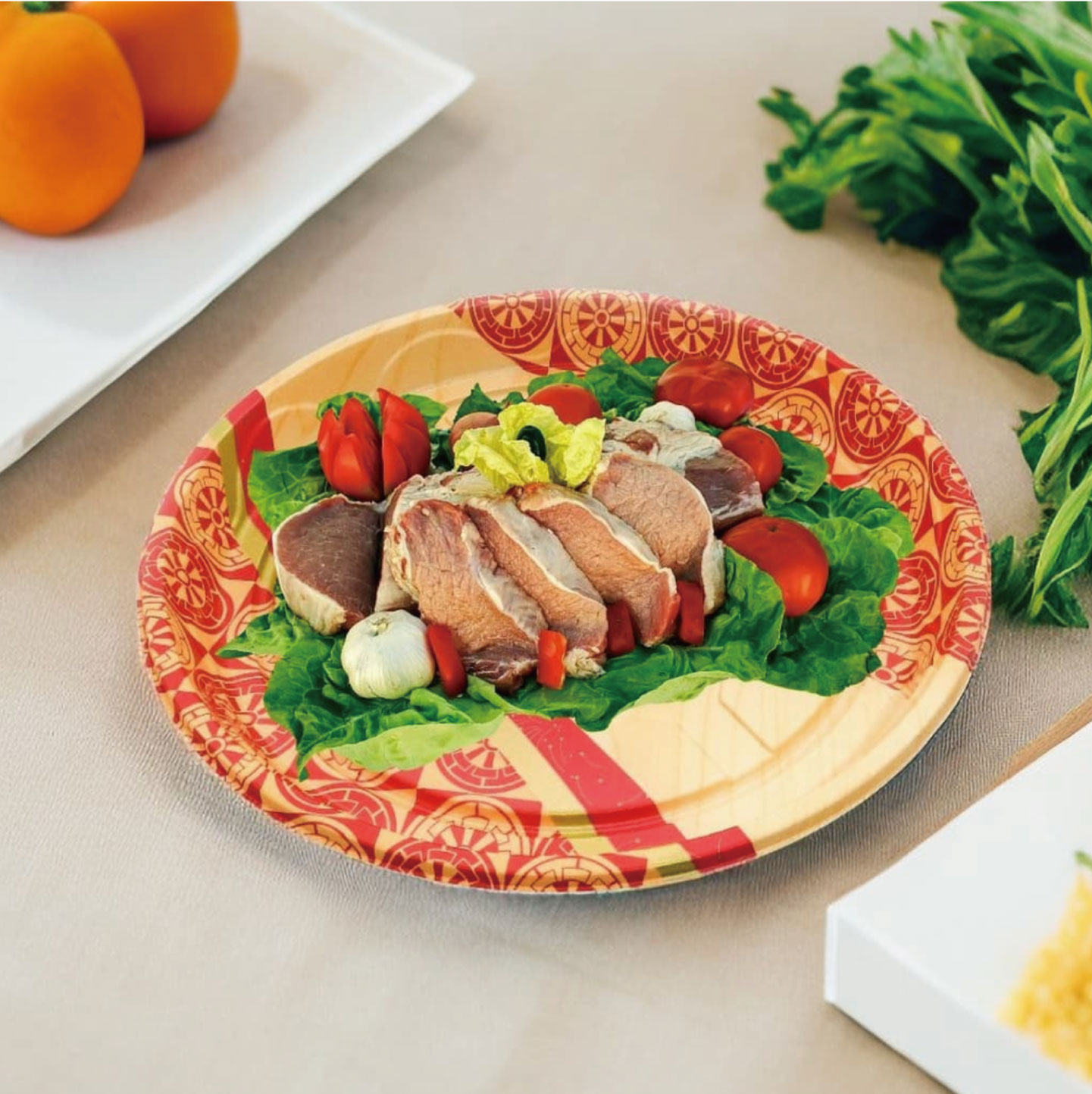 Sliced meat with lettuce, cherry tomatoes, and garlic on a colorful plate, garnished with leafy greens.